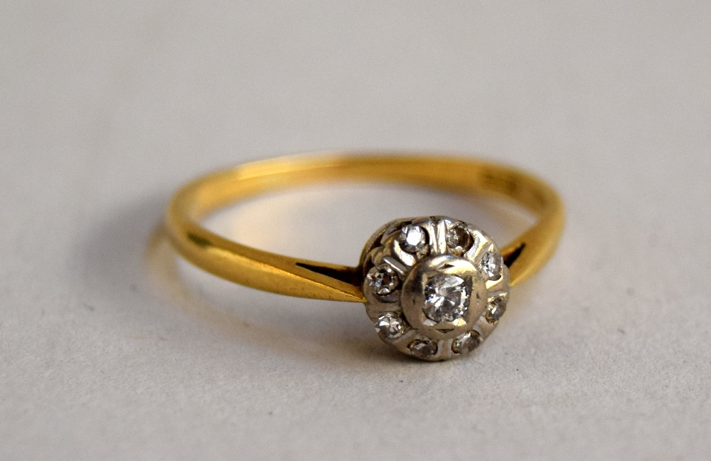 An Art Deco 18ct illusion setting diamond ring with eight small stones around a larger central