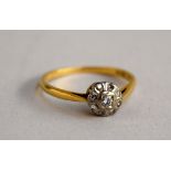 An Art Deco 18ct illusion setting diamond ring with eight small stones around a larger central