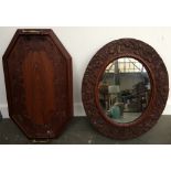 A mahogany framed oval mirror with carved foliate design, 53x44cm, along with a wooden tray,