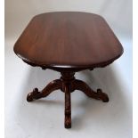 A large one piece dining table on two pedestal tripod carved supports,