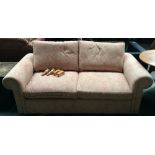 A modern chesterfield style sofa upholstered in floral fabric raised on turned oak legs,