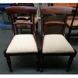 A pair of mahogany dining room chairs with striped fabric seats