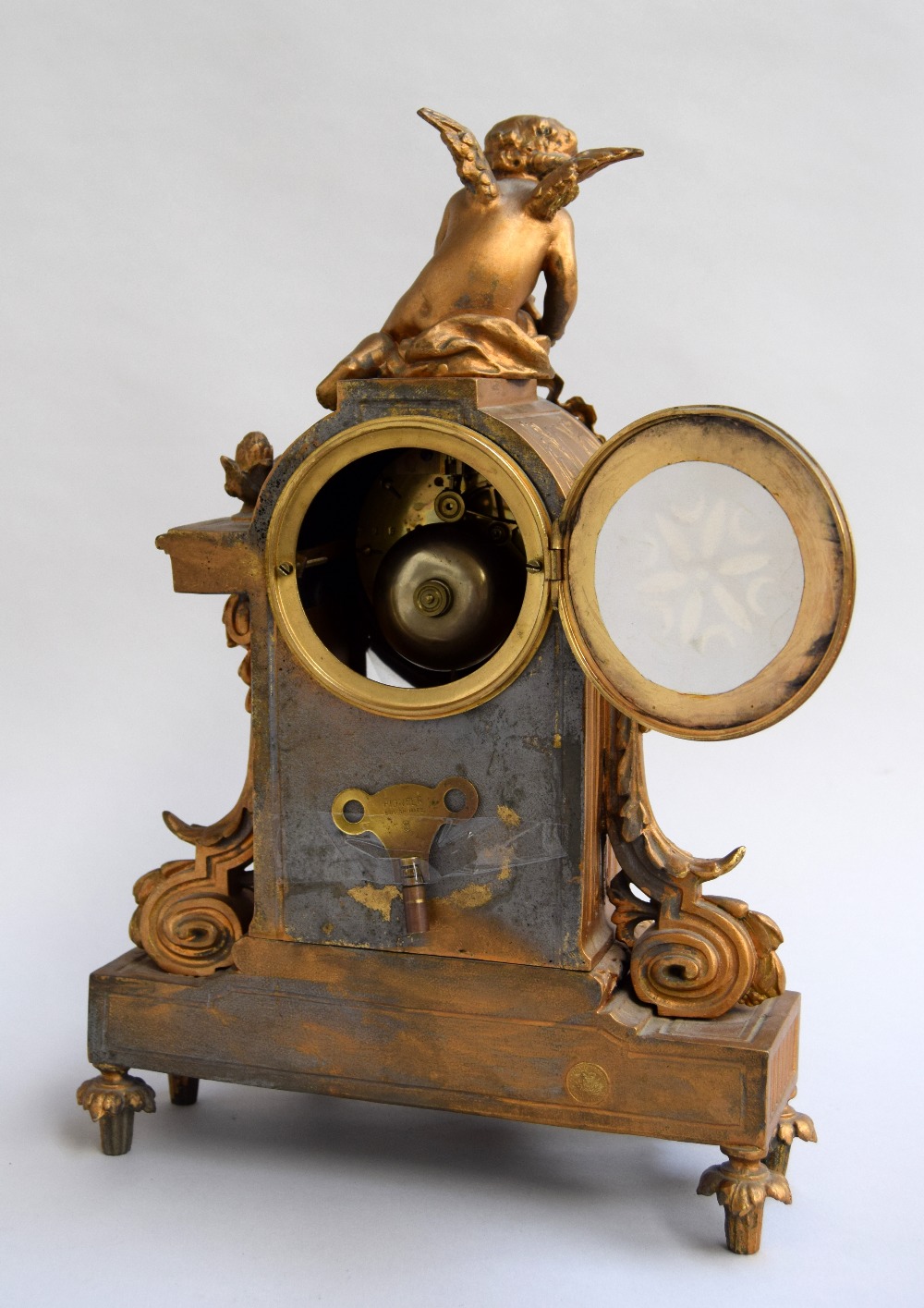 An antique French gilt bronze mantel clock, surmounted by a winged cherub, with two doves to base, - Image 2 of 2