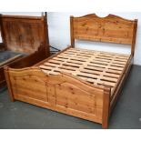 A pine double bed with two drawers to each side