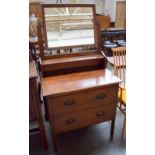 An oak dressing table with tilting mirror above shelf and two long drawers