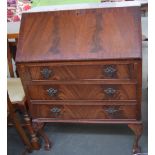 A bureau with fitted interior over three drawers,