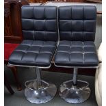 Two chrome and black leather barstools, with backs and foot rests,