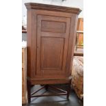 A Victorian oak corner cupboard with two shelves, raised on a stand, 85.