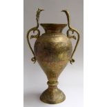 An Indian brass vase with cobra head handles, incised with floral patterns a figures,
