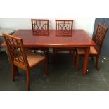 An extending cherry wood dining table with four dining chairs