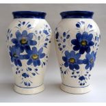 A pair of very large vases, in white, decorated with large blue flowers,