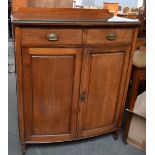 A bow fronted cupboard with two drawers above,