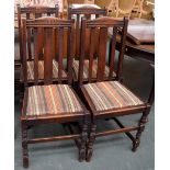 A set of four oak dining chairs with drop in seats upholstered in a striped fabric,