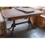 An extending table with central leaf, raised on turned pillars and sabre legs,