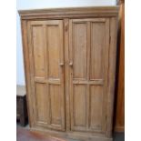 A Victorian or earlier stripped pine cupboard with two doors,