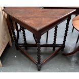 An oak corner table with drop leaf and gateleg, raised on barley twist legs,