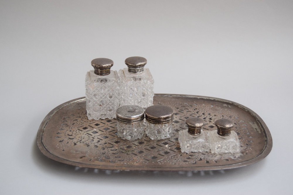 A matched set of six silver and cut glass toiletry bottles,