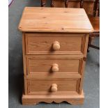 A pine bedside chest of three drawers