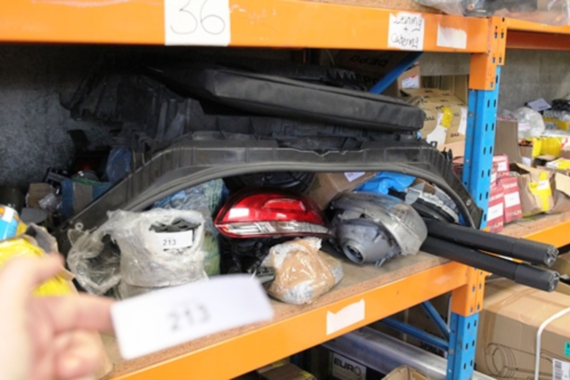 Approximately a half shelf of car spares including headlights, parcel shelf, mirrors, clocks