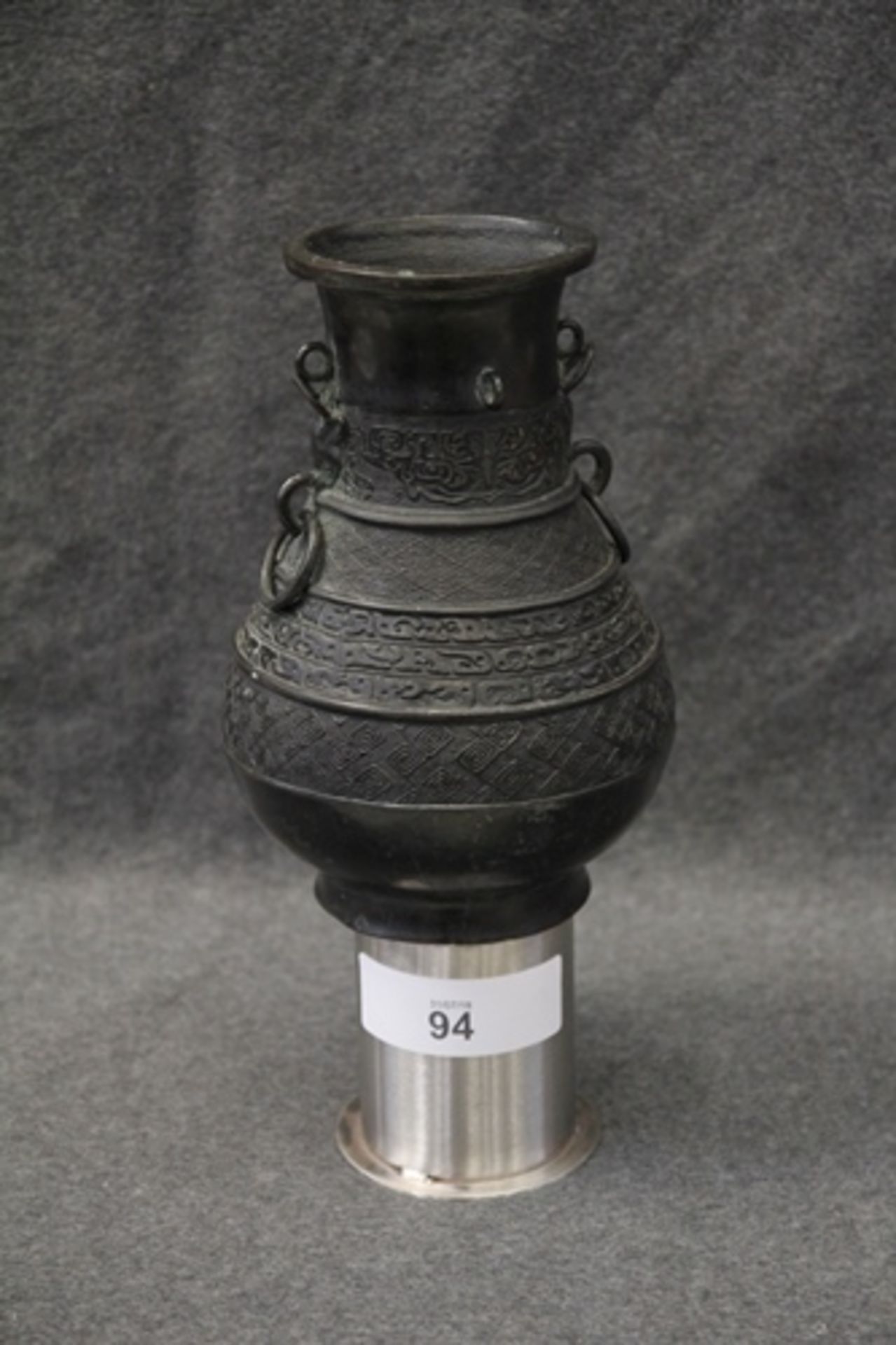 Oriental bronze baluster jug with loop handles and embossed decoration. Script mark to base, 26.5 cm