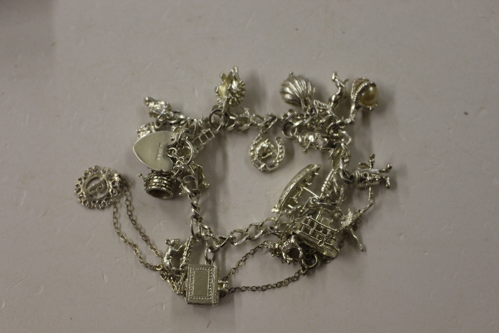 A silver charm bracelet hung with various charms