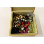 A wooden box of costume jewellery