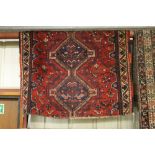 An approx. 69" x 56" red patterned rug