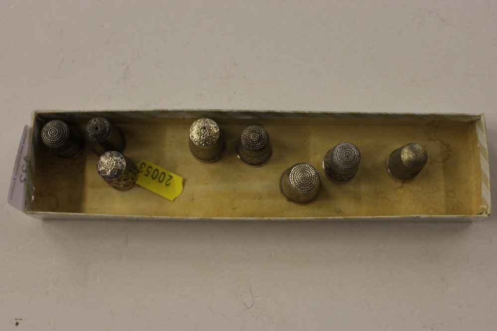 A tray of 8 silver thimbles