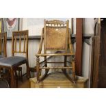 A mahogany rocking chair with poker work seat and