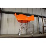 A retro style luminous orange chair, raised on chrome base