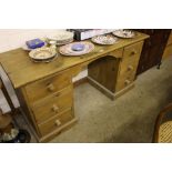 A stripped pine desk fitted six drawers