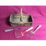 A wicker basket and three vintage garden tools