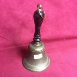 An old school bell, having turned wooden handle