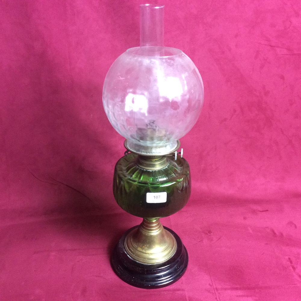 A Victorian oil lamp with green glass font