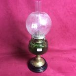 A Victorian oil lamp with green glass font