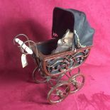 A doll's pram and porcelain headed doll