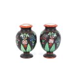 A pair of Prattware baluster vases, profusely decorated with flowers on a black and ochre ground,