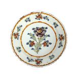 An 18th Century Delft polychrome charger, having floral decoration, 35cm dia., AF