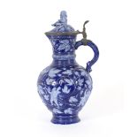 A continental blue glazed porcelain flagon, having raised floral and berry decoration, the lid