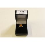 A silver and orange stone set dress ring