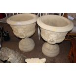 A pair of large concrete garden urns