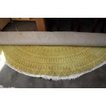 An 8'10" circular yellow patterned rug