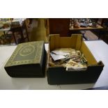 A box containing apost-card album and loose post-c