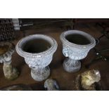 A pair of large concrete garden urns decorated wit