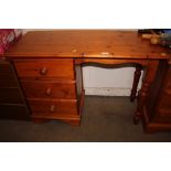 A pine knee hole desk fitted three drawers