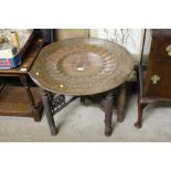 An Eastern brass top table on stand