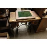 An oak and cast iron sewing machine table