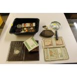 A box containing a magnifying glass, coins purses