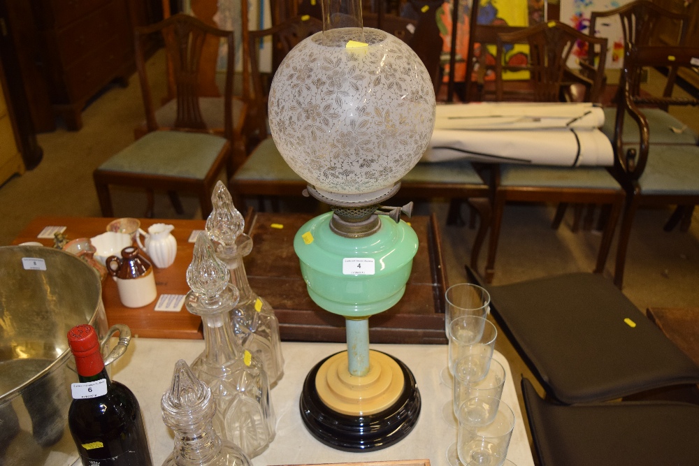An Art Deco oil lamp with etched glass shade