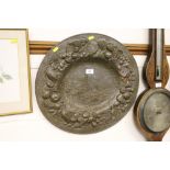 A heavy metal platter with bird and fruit decorati